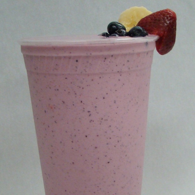Fruit smoothie in a clear cup with a straw